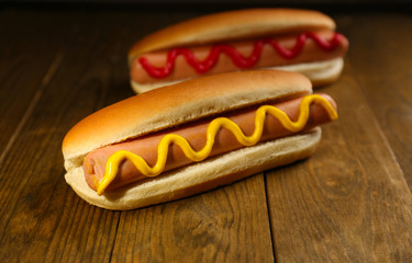 Tasty hot dogs on wooden table