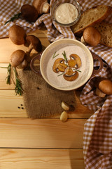 Mushroom soup in pot, on napkin,  on wooden background