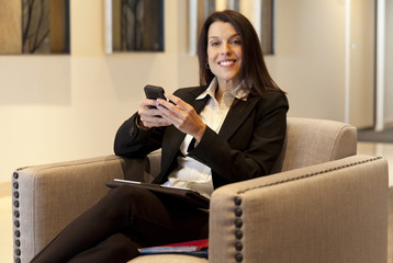 Beautiful Smiling Businesswoman working on tablet at the hotel