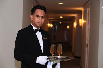waiter or butler in uniform at five star hotel corridor