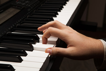 Fototapeta premium Piano keys and human hand