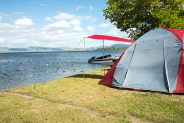 Foto op Aluminium Tent on a camping site near a lake © anastasstyles