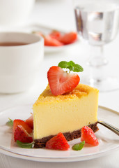 Slice of cheesecake with strawberries and strawberry sauce.