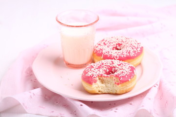sweet donut with pink icing and milk