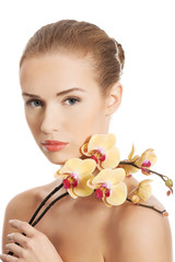 Fototapeta premium Portrait of beautiful caucasian woman with orchid flower.