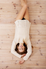 Beautiful carefree young casual woman lying on the floor.