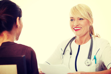 Mature female doctor talking with patient.