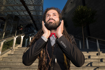 Stylish elegant dreadlocks businessman listening music