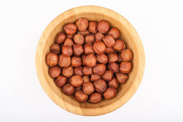 Hazelnits in wooden bowl isolated on white background