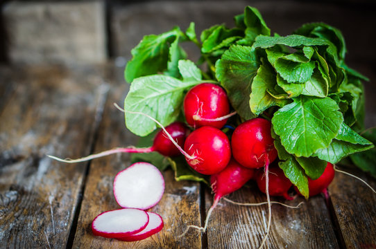 Radishes on rustic wooden background