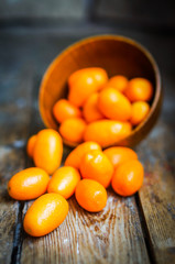 Kumquat in a bowl on rustic wooden table