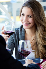Young loving couple toasting with wine at restaurant