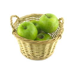 Ripe green apples in light brown wicker basket isolated closeup