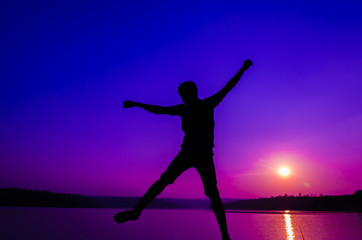 Fototapeta na wymiar silhouette jumping man on the lakeside