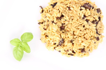 Risotto with mushrooms on a plate decorated with basil