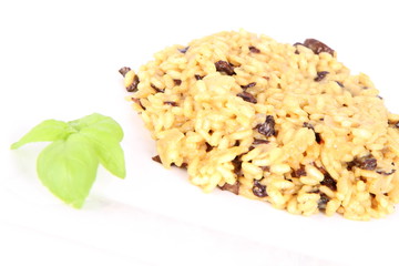 Risotto with mushrooms on a plate decorated with basil
