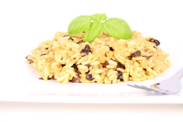 Risotto with mushrooms on a plate decorated with basil