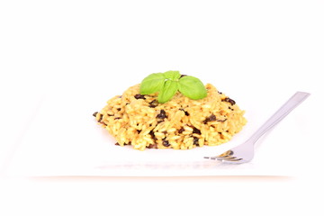 Risotto with mushrooms on a plate decorated with basil