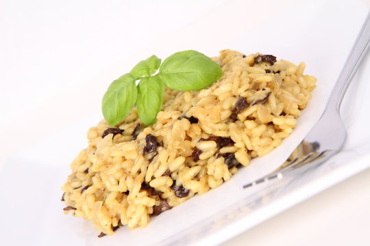 Risotto with mushrooms on a plate decorated with basil