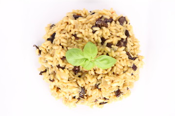 Risotto with mushrooms on a plate decorated with basil