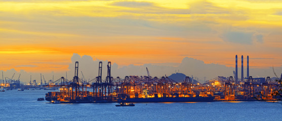 Silhouette of several cranes in a harbor, shot during sunset.