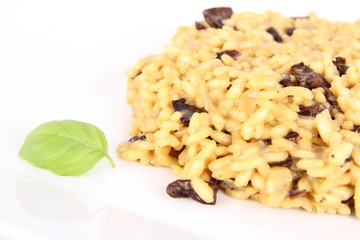 Risotto with mushrooms on a plate decorated with basil