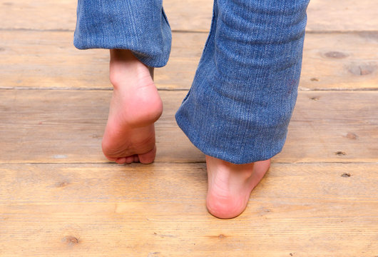 Barefoot girl walking on wooden floor