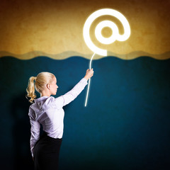 junge Frau hält E-Mail Symbol fest