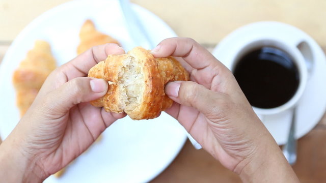 woman hand black coffee cup and croissant
