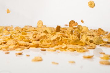Cornflakes falling into a pile, over white background