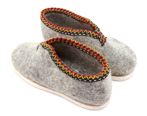 Two traditional grey felt slippers posed heel to toe