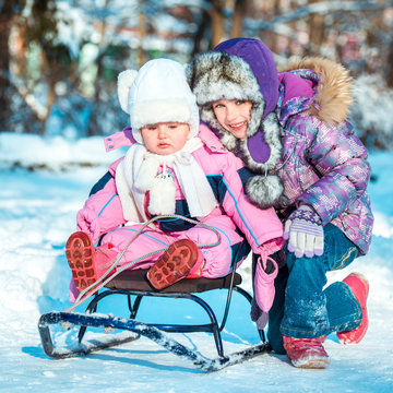 two little sisters on a sled