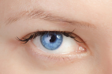 Blue eye with colored contact lenses close-up.