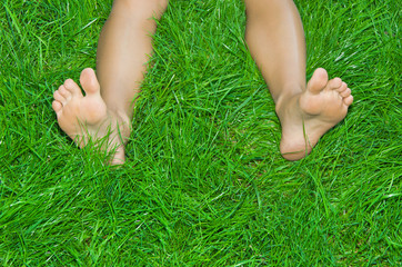 Female  legs are in a green grass
