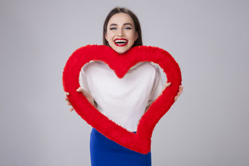 Young woman laughing and holding a red valentines heart