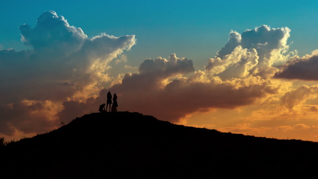 People silhouettes on sunset sky background.