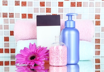 Obraz na płótnie Canvas Cosmetics and bath accessories on mosaic tiles background