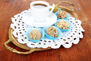 Set of chocolate candies, on tray, on wooden background