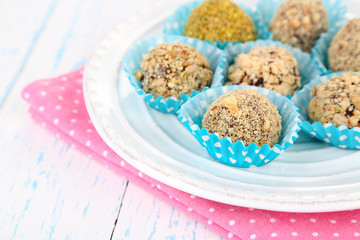 Set of chocolate candies, on plate, on wooden background