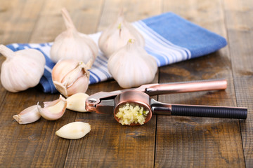 Fototapeta na wymiar Garlic press on wooden background