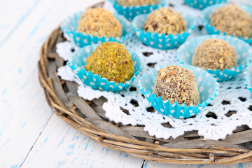 Set of chocolate candies, on wicker mat, on wooden background
