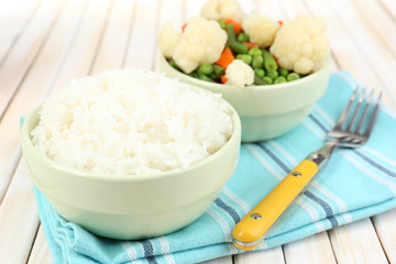 Cooked rice with vegetables on wooden table close up