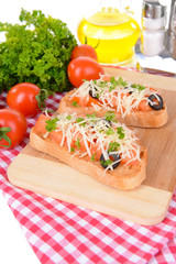 Delicious bruschetta with tomatoes on cutting board close-up