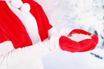 Girl in Christmas red cape and gloves, on winter background