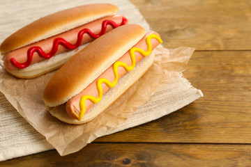 Tasty hot dogs on wooden table
