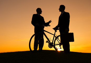 Businessmen with a Bicycle at Sunset