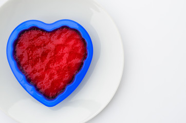 Fototapeta na wymiar Heart shaped red gelly on white dish