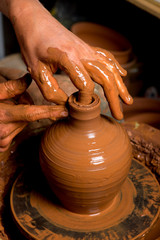hands of a potter, creating an earthen jar