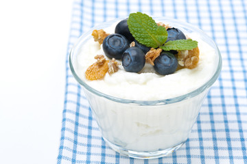 homemade yogurt with blueberries and muesli in a glass, isolated