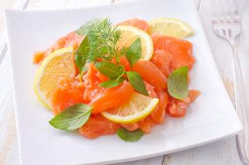 fresh salmon with lemon on the white plate